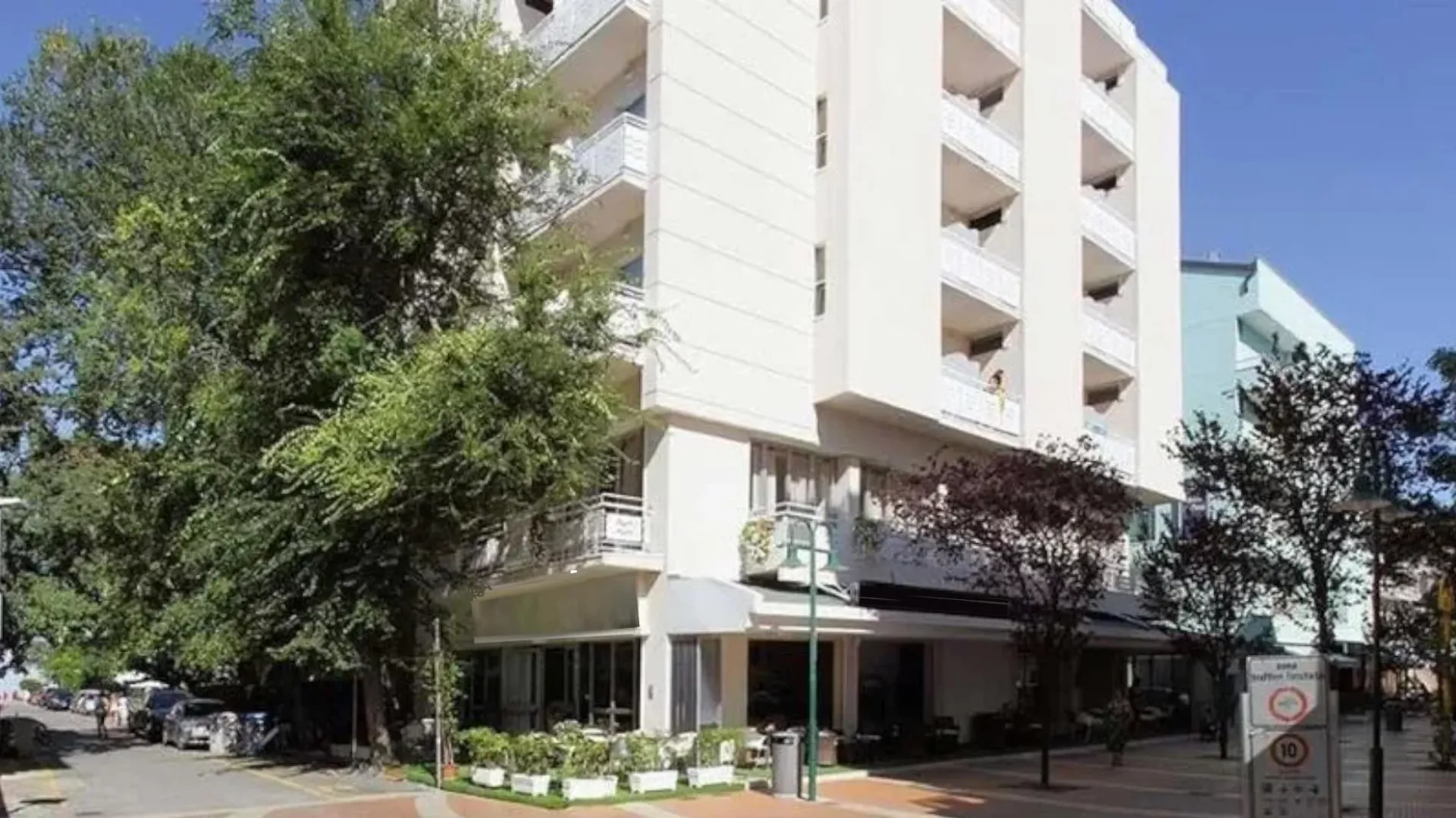 Edificio residenziale moderno con balconi, situato in una strada alberata e tranquilla.