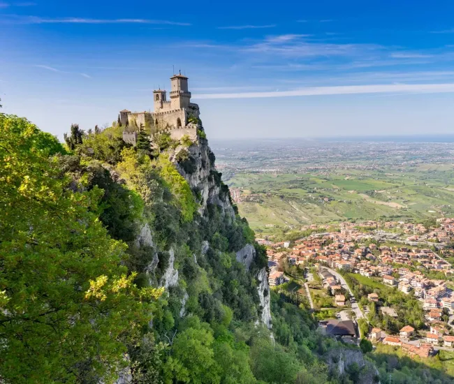 Castello sulla cima di una montagna con vista panoramica sulla valle sottostante.
