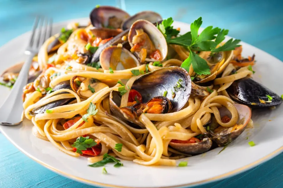 Deliziosi spaghetti con frutti di mare, prezzemolo fresco e pomodorini.
